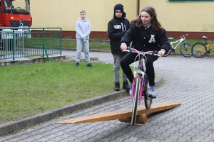 Dziewczynka jadąca rowerem, pokonująca przeszkodę.