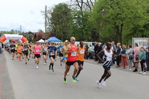 Duża grupa ludzi w strojach sportowych biegnie.