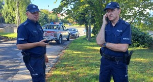 Dwóch policjantów prowadzi korespondencję radiowa.