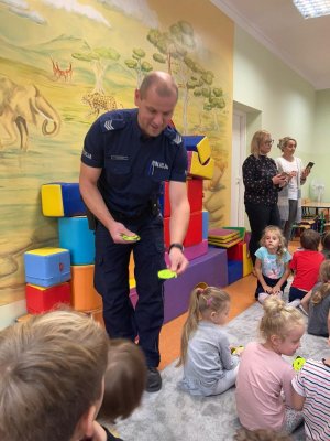 Policjantka, policjant i policyjny pingwin podczas spotkania w szkole z dziećmi.