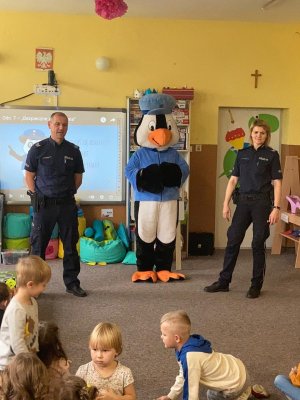 Policjantka, policjant i policyjny pingwin podczas spotkania w szkole z dziećmi.