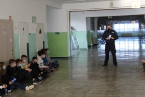 Policjanci i dzieci na korytarzu w szkole.