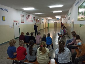 Policjant i dzieci na korytarzu w szkole.