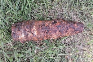 Niewybuch leżący na trawie.