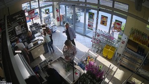 Mężczyzna i dwie kobiety stoją w pobliży kasy w markecie, przy drugiej kasie stoi kobieta.