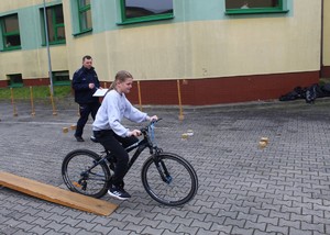 Dziewczynka jadąca rowerem, pokonuje przeszkodę na torze.