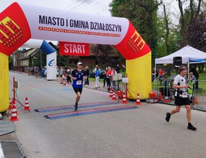 Trzech mężczyzn w strojach sportowych stoją na ulicy.