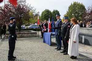 Kadet składa meldunek policjantowi, strażakowi, dyrektorce szkoły.