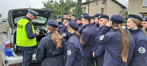 Policjant tłumaczy grupie uczniów z klasy mundurowej.