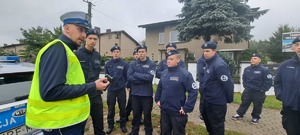 Policjant tłumaczy grupie uczniów z klasy mundurowej.