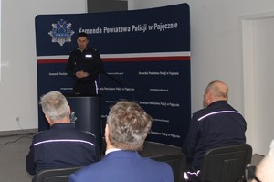 Na zdjęciu widać jak umundurowany policjant przemawia.