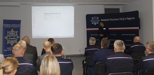 Na zdjęciu widać jak umundurowany policjant przemawia.