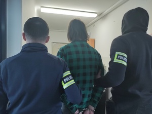 Dwóch policjantów i zatrzymany mężczyzna.