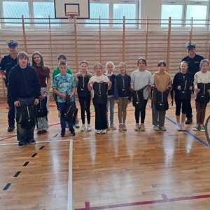 Grupa dzieci i dwóch policjantów.