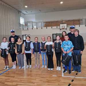 Grupa dzieci i dwóch policjantów.