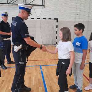 Policjant gratuluje dziewczynce.