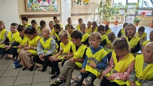 Dzieci w kamizelkach odblaskowych.