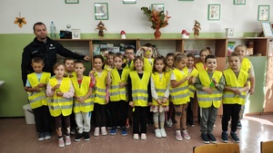 Dzieci w kamizelkach odblaskowych.