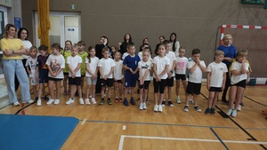 Grupa dzieci na sali gimnastycznej.